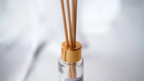 Wooden sticks inserted in a reed diffuser bottle. White environment Stock Footage 138679899
