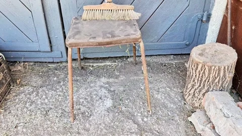 Wooden Stool with Broom and Tree Stump Outside a Rustic Building Vídeos de archivo 346119408