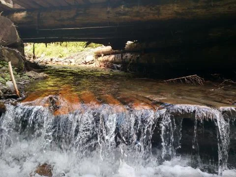 Wooden structure artificial waterfall under the man-made bridge Channel conce Stock Photos