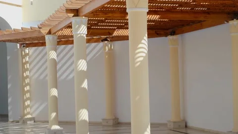 The wooden structure of the gazebo is supported by smooth cylindrical white colu 스톡 동영상 237447546