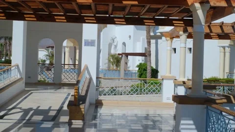 The wooden structure of the gazebo is supported by smooth cylindrical white colu Stock Footage 237449536