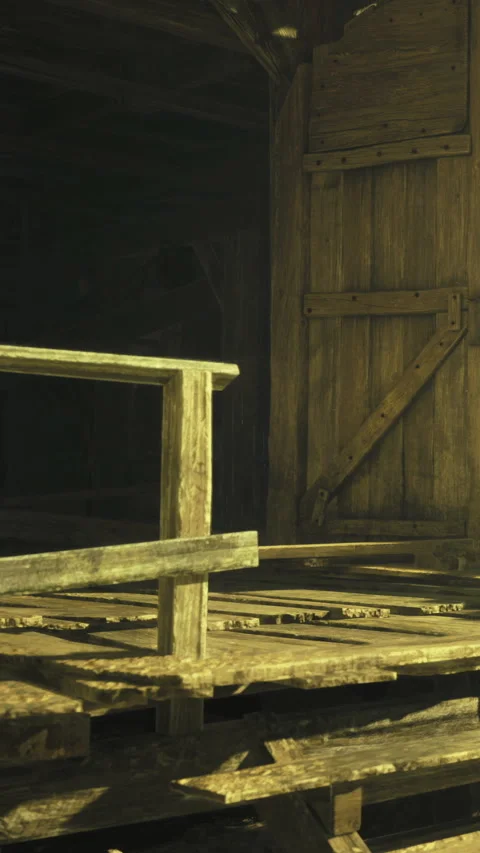Wooden structure stands inside a dark barn during evening hours near a doorway Stock Footage 332211702