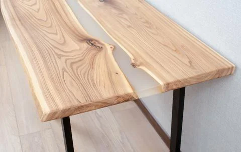 Wooden stylish table made of solid wood with epoxy resin on the background of Stock Photos