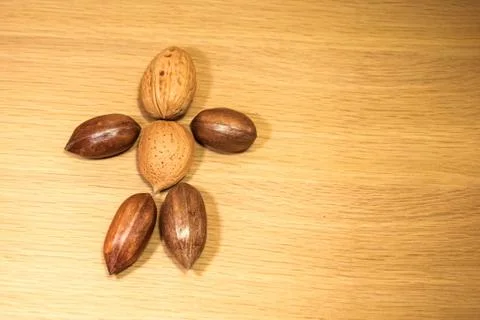 On a wooden surface are nuts of different varieties. Stock Photos