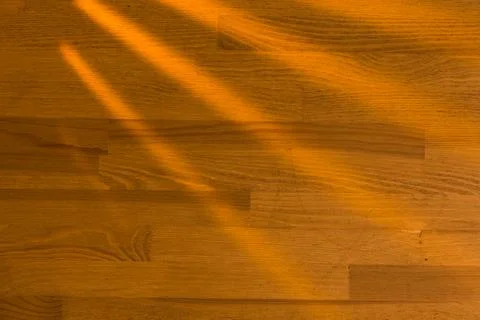 Wooden surface as background texture with rays of light. Stock Photos