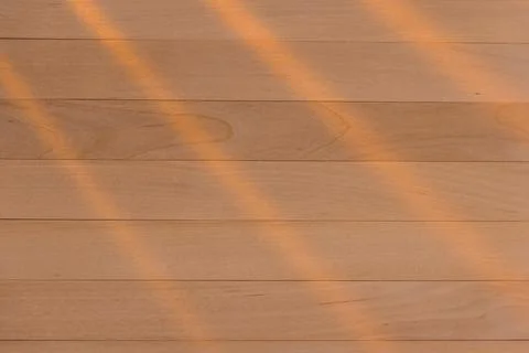 Wooden surface as background texture with rays of light. Stock Photos