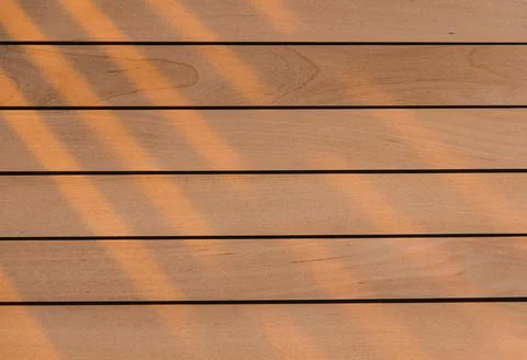 Wooden surface as background texture with rays of light. Stock Photos