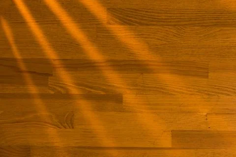 Wooden surface as background texture with rays of light. Stock Photos