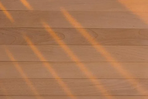 Wooden surface as background texture with rays of light. Stock Photos