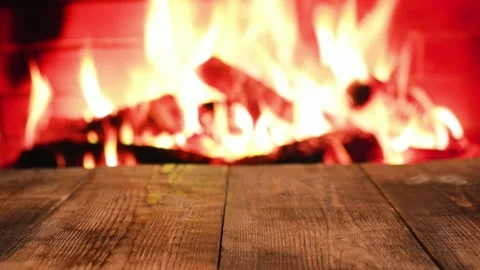 Wooden table against the background of a burning fire in the fireplace. Stock-Footage 220134476