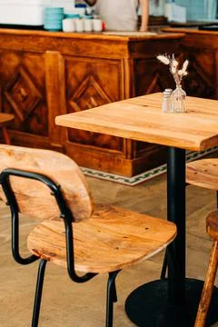 Wooden table and chair in cafe. Details of restaurant interior design Stock Photos