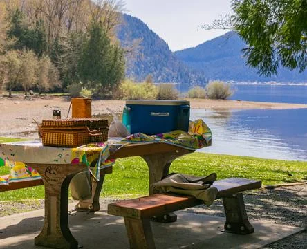 Wooden table with boxes and baskets of food for the outdoor picnic in a park  Stock Photos