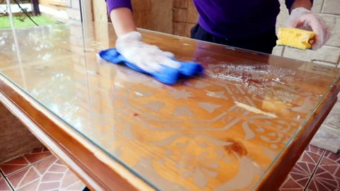 A wooden table in a cafe is washed with a sponge and detergent. spring-cleaning Vidéo 169357710