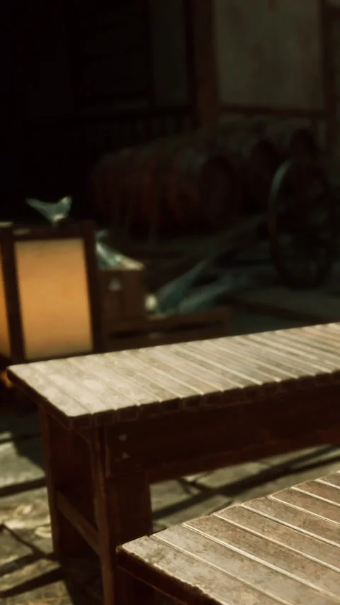 Wooden table in a courtyard with lanterns and barrels in background at dusk Stock Footage 341256241