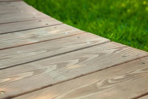 Wooden table in diagonal on the image with blurred summer green background Stock Photos