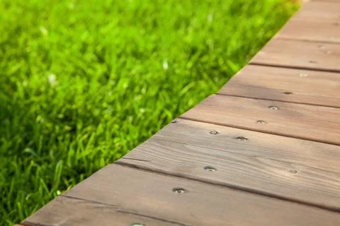 Wooden table in diagonal on the image with blurred summer green background Stock Photos