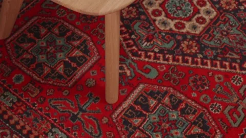 Wooden table edge surface over vibrant red floor carpet 스톡 동영상 346159510