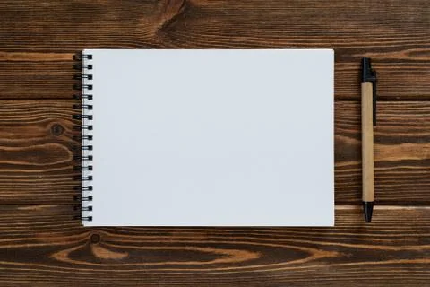 A wooden table. Empty notebook and pen - top view. High resolution photo. Stock Photos