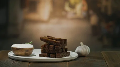 A wooden table is served with deep-fried croutons and garlic sauce in bowl Stock Footage 94670371