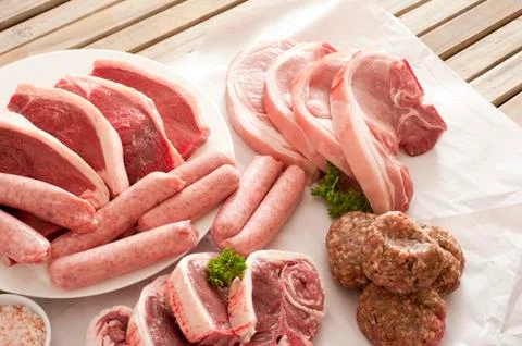 Wooden table set with selection of meat cuts Stock Photos