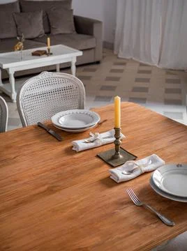 Wooden table setting for two persons, with plates, cutlery and old candlestic Photos