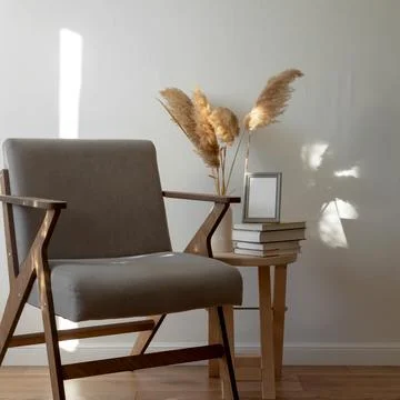 Wooden table with stack of books and vase with pampas grass, mock-up gray fra Stock Photos