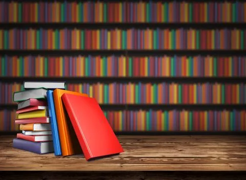 Wooden table with a stack of colored books. Blurred background. Back to school Illustrazione stock