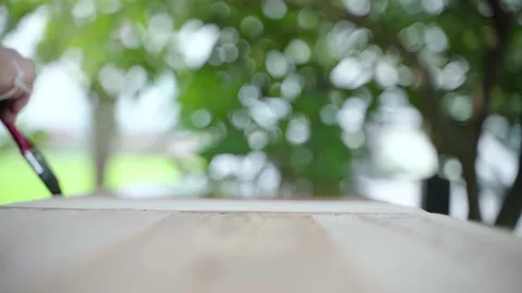 Wooden table surface with hand using brush Stock Footage 141911137