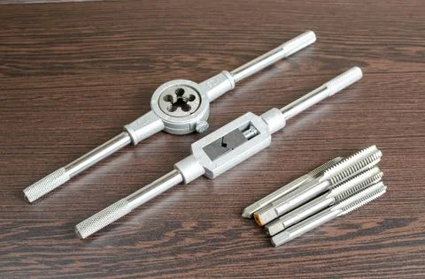 On a wooden table a tool for cutting a thread close-up Stock Photos