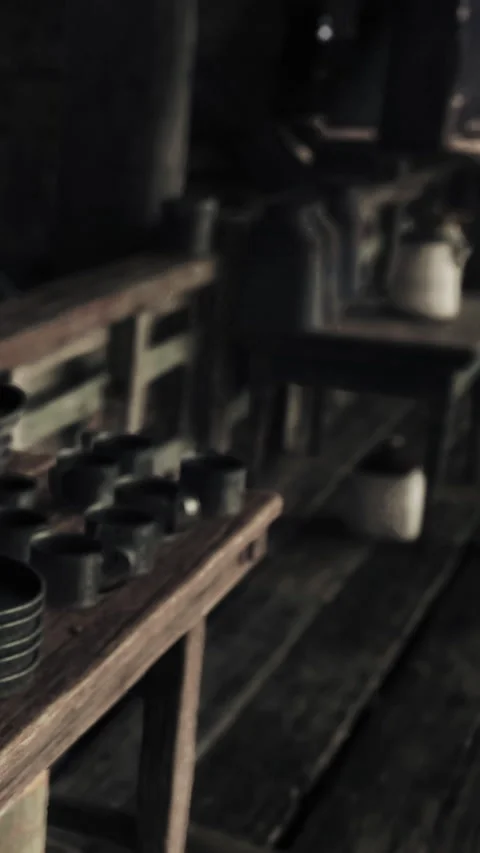 Wooden table with various cups in a rustic kitchen setting during daytime Stock Footage 340256842