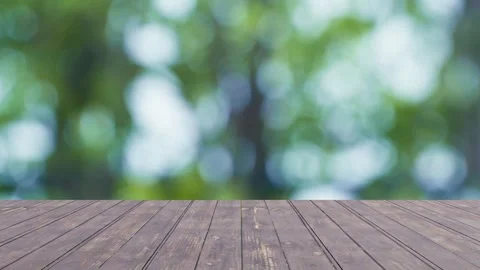 Wooden tabletop on focus with blurred leaf nature background fresh  green bokeh  Stock Footage 240536165