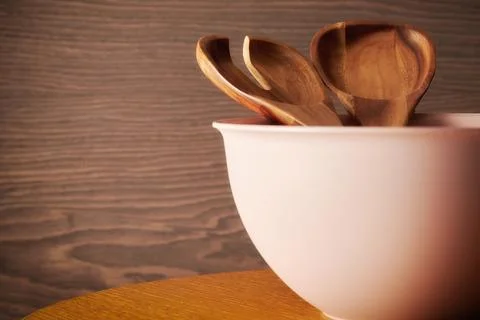 Wooden tableware in a bow on a kitchen table. Kitchen spoon and fork Stock Photos