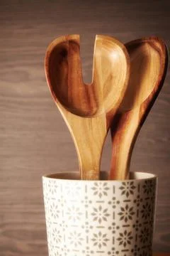 Wooden tableware in the cup on a kitchen table. Kitchen spoon and fork Stock Photos