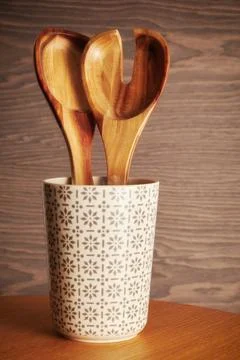 Wooden tableware in the cup on a kitchen table. Kitchen spoon and fork Stock Photos