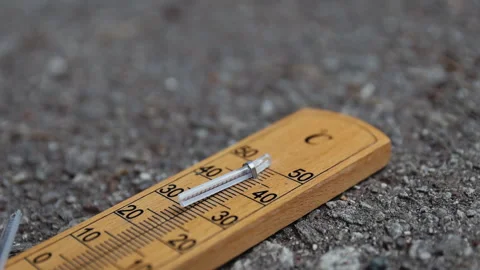 A wooden thermometer broken by a hammer on asphalt, symbolizing sharp tempe.. 스톡 동영상 344885341