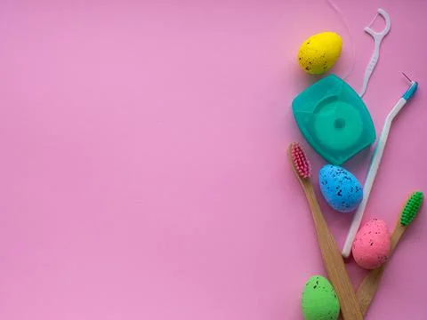 Wooden toothbrushes with Easter decorations on pink background Stock Photos