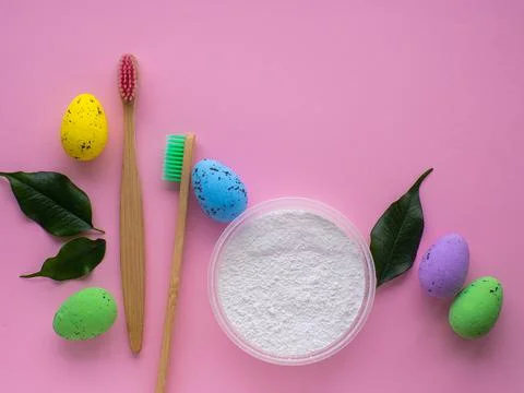 Wooden toothbrushes with Easter decorations on pink background Stock Photos