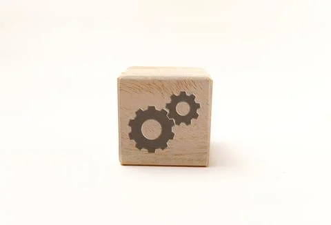 Wooden toy block featuring two black gear icons, representing settings or p.. Stock Photos