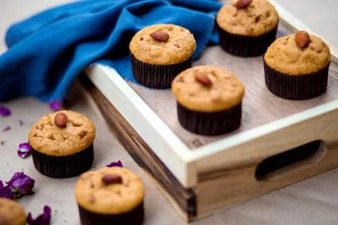 A wooden tray with basic muffins with almond on top Stock Photos