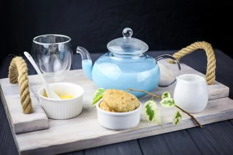 A wooden tray served with blue butterfly tea with milk, honey,cookies Stock Photos