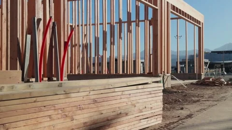 Wooden wall framing at active construction site with mountains in background Stock Footage 332823050