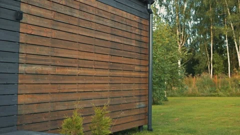 The wooden wall is shown in different angles, with a green lawn and trees in the Stock Footage 345874941