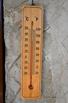 Wooden wall thermometer on rough concrete Stockfoto's