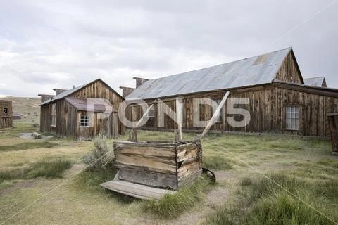 Wooden well and barn in field, Bodie Stock Photos