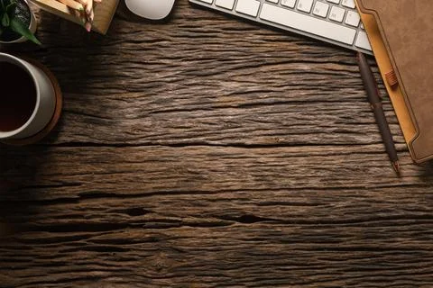 Wooden working desk with notebook, computer keyboard, mouse and cup of coff.. Stock Photos