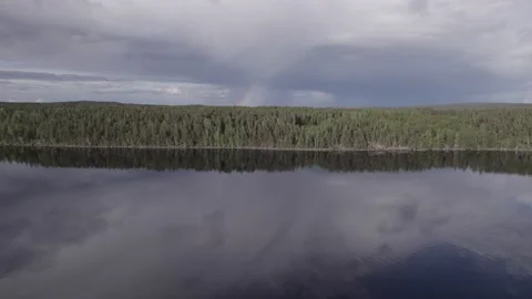 Woods reflected on lake with rainbow Stock Footage 195844080