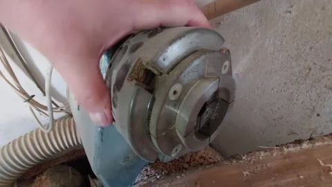 Woodturner checking a metal scroll chuck on a wood lathe next to a raw log Stock Footage 335644449