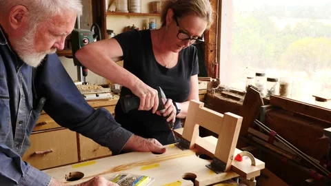 Woodwork assembling screwing timber older gentleman and lady assistant Vidéo 231894325