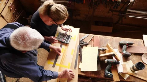 Woodwork marking measuring calculating timber older gentleman and lady assis Stock Footage 231892817