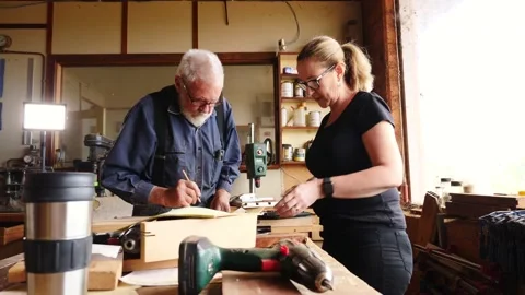 Woodwork marking measuring planning timber older gentleman and lady assistan Vidéo 231892611